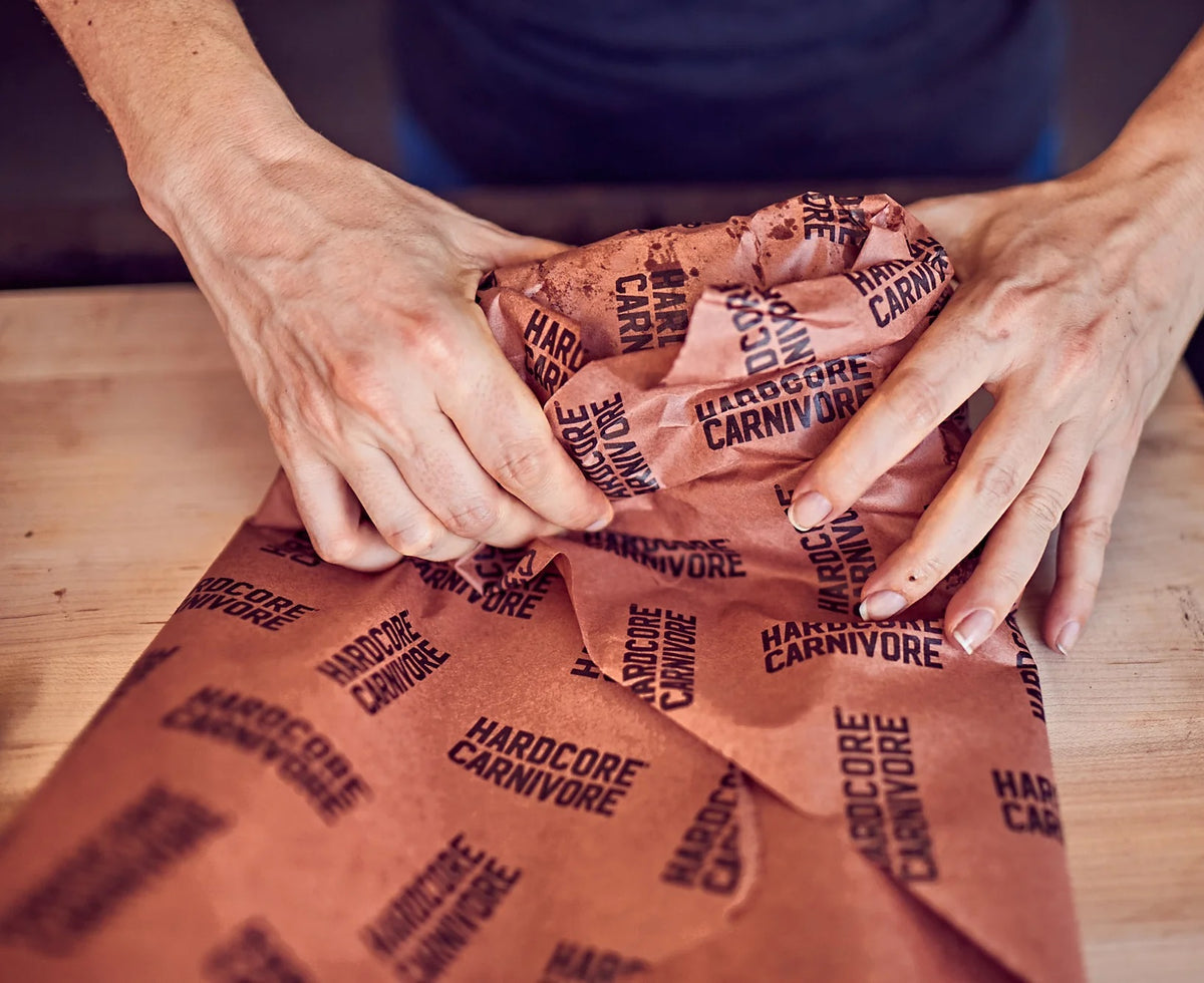 Wrapping smoked brisket using pink butcher paper for bark retention