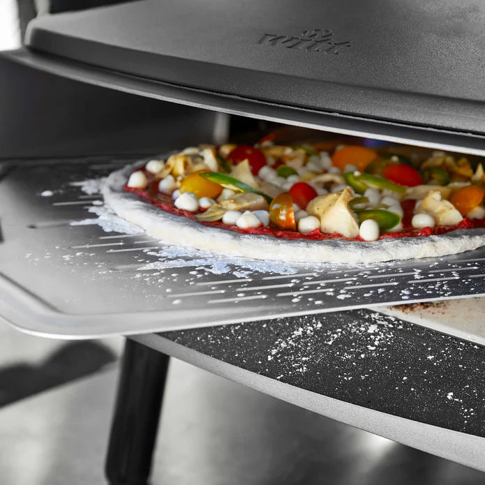 Witt 12-inch pizza peel sliding topped pizza into Witt Pizza oven