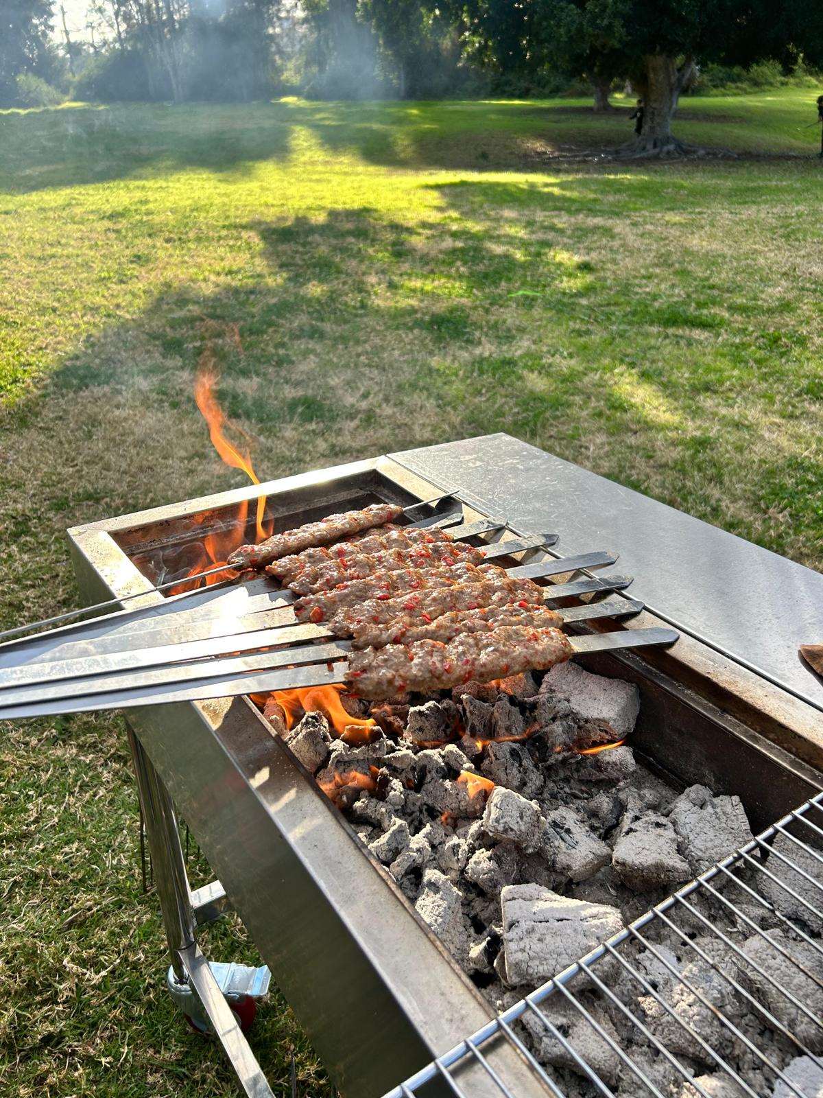 adana skewers cooking on portable charcoal bbq