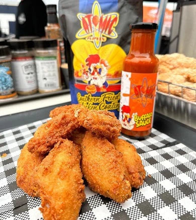 Fried chicken wings with Atomic Chicken buffalo sauce on a checkered tray