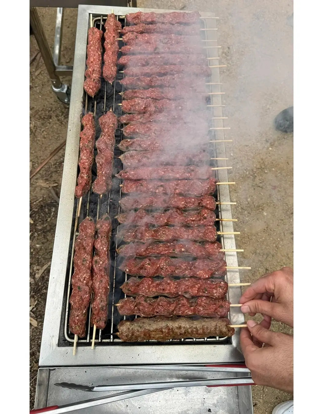 Charcoal grilled mince kofta kebabs cooking on skewers