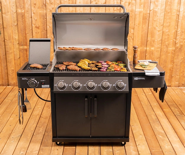Coleman Pro Series 5 burner BBQ cooking multiple foods outdoors