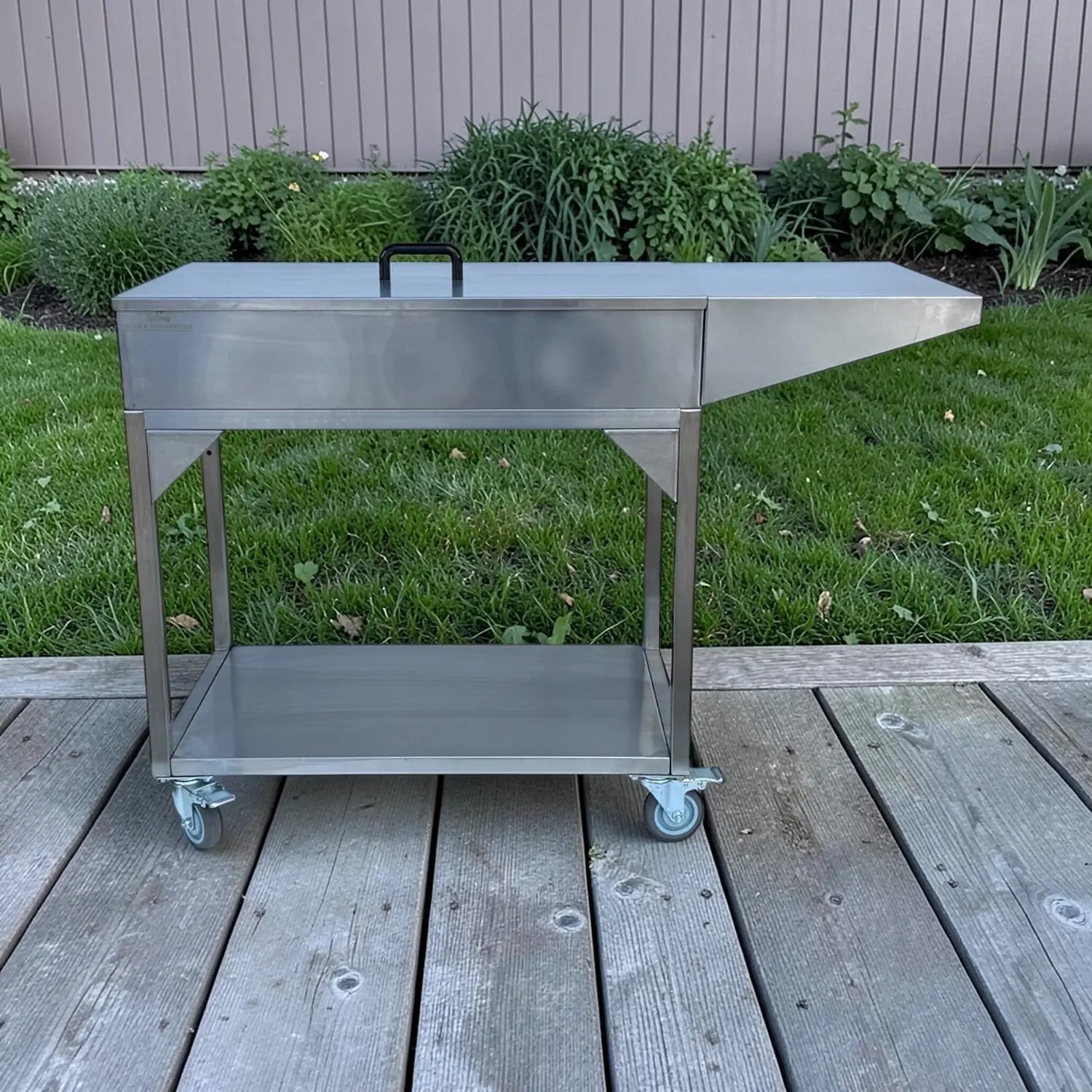 Family Barbecue HD charcoal BBQ on outdoor deck with side bench and storage shelf