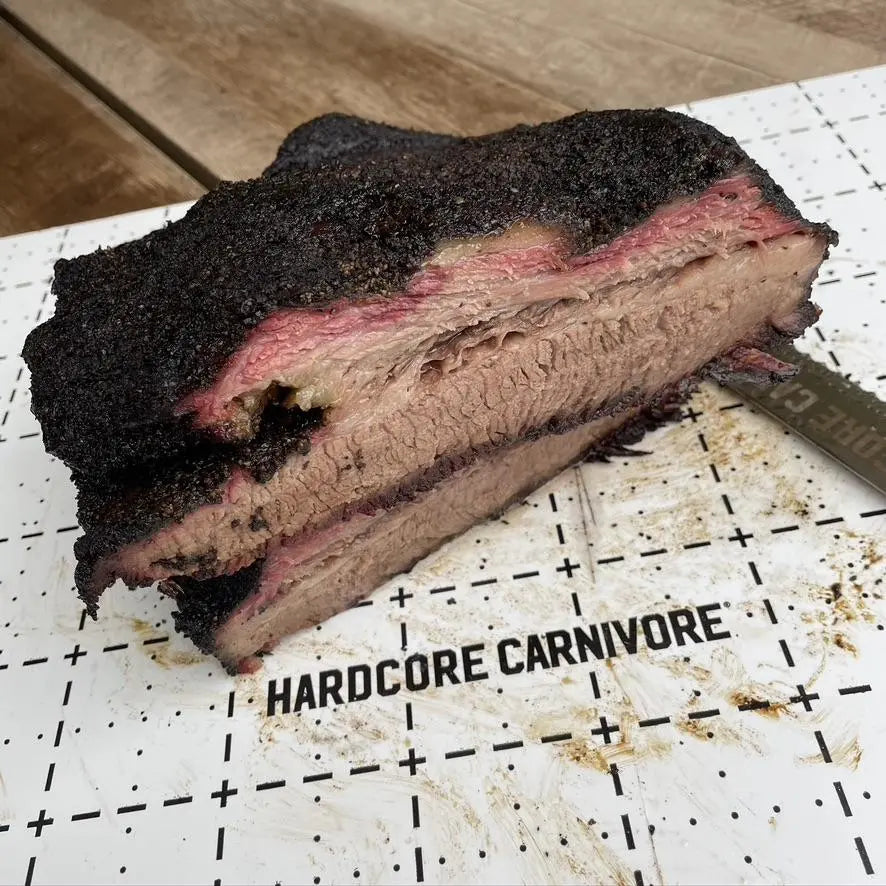 Hardcore Carnivore disposable cutting board with sliced smoked brisket on BBQ prep surface