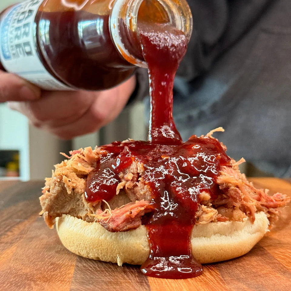 Hardcore Carnivore Saucesome BBQ sauce poured over pulled pork burger