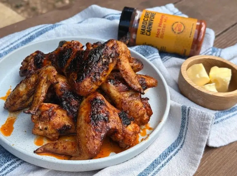 Hot Honey Butter Mix used on grilled chicken wings with dipping butter on a white plate