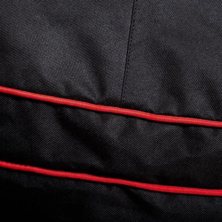 Close-up of the black Kamado Joe grill cover fabric with red trim