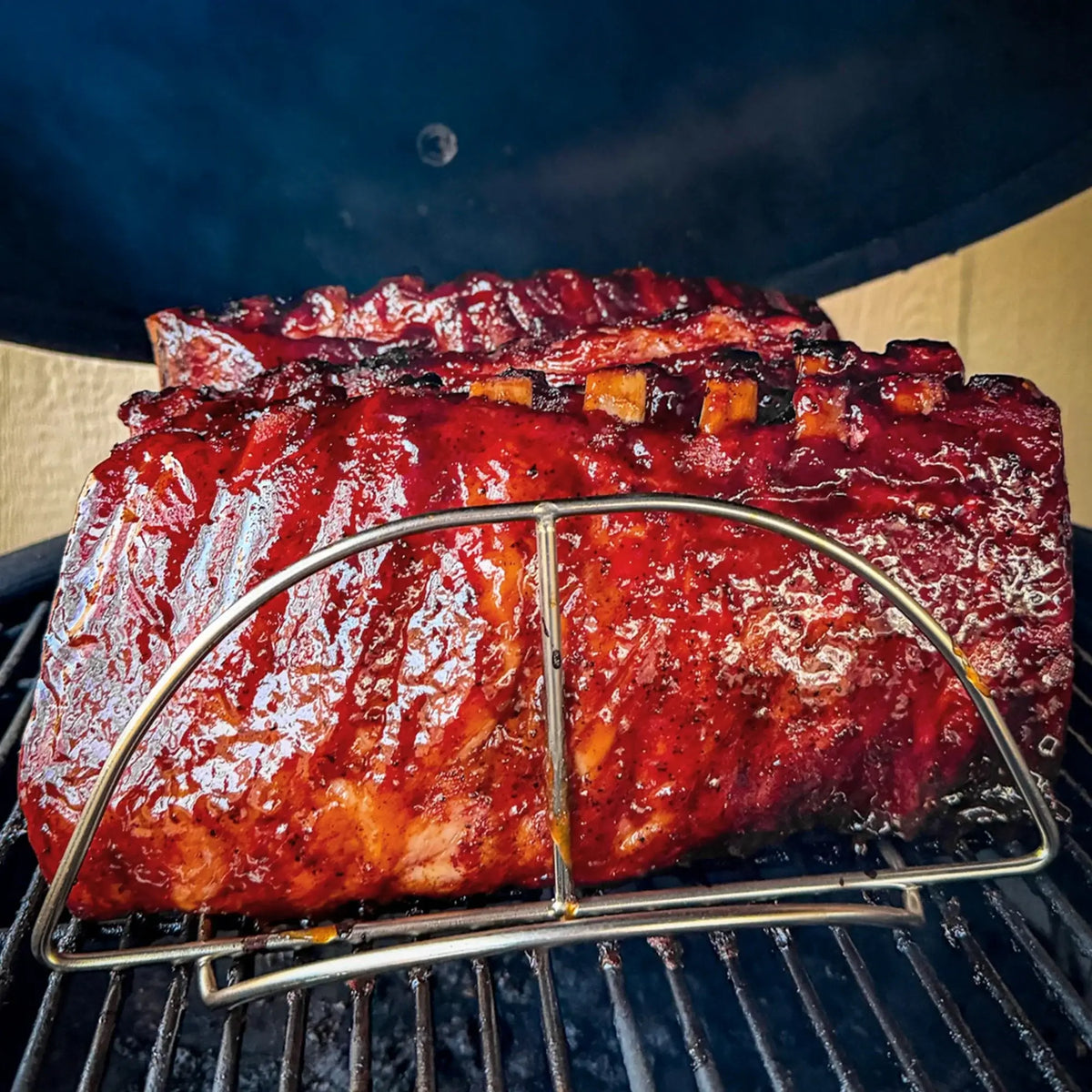 BBQ ribs cooking vertically in a Kamado Joe rib rack