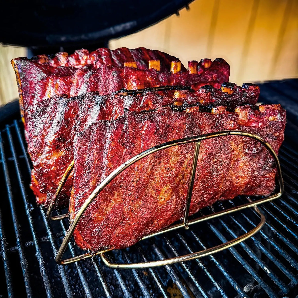Kamado Joe rib rack holding multiple racks of ribs vertically on a grill