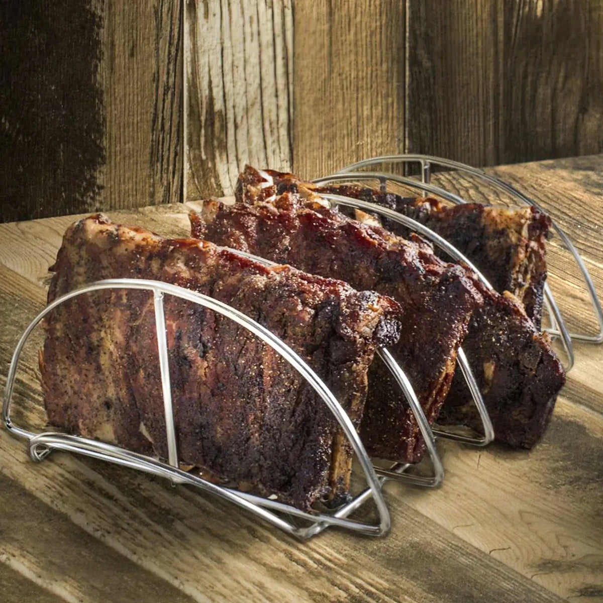 Pork ribs held vertically in a Kamado Joe stainless steel rib rack