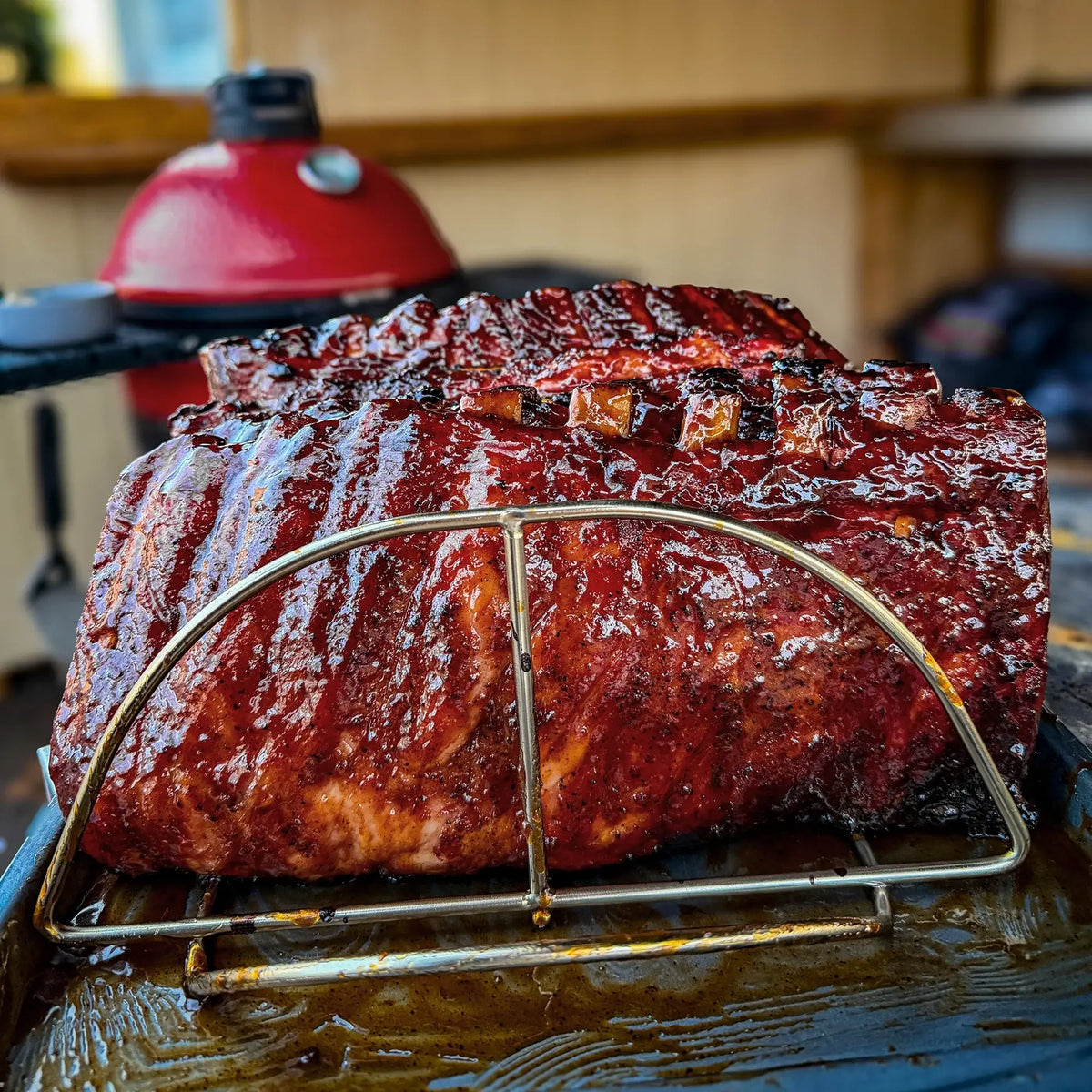 Kamado Joe rib rack holding smoked ribs on a BBQ