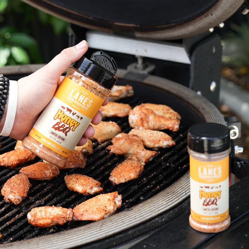 Lane’s Honey BBQ Rub being used on chicken wings cooking on BBQ grill