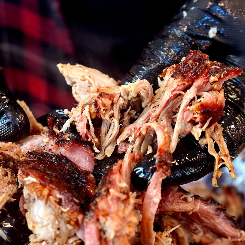 Pulled pork cooked with Lane’s Magic Dust BBQ rub showing tender shredded meat and bark