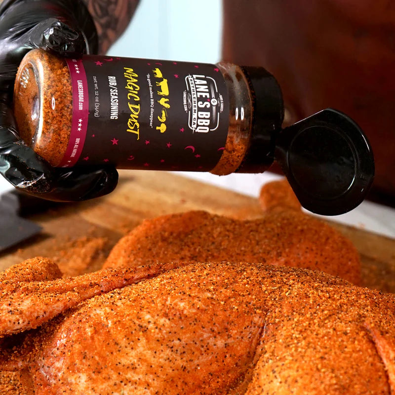 Whole chicken being coated with Lane’s Magic Dust BBQ rub before roasting