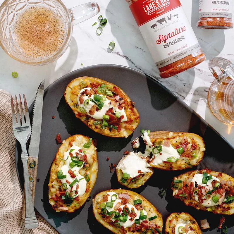 Loaded baked potatoes topped with seasoning using Lane’s Signature BBQ Rub