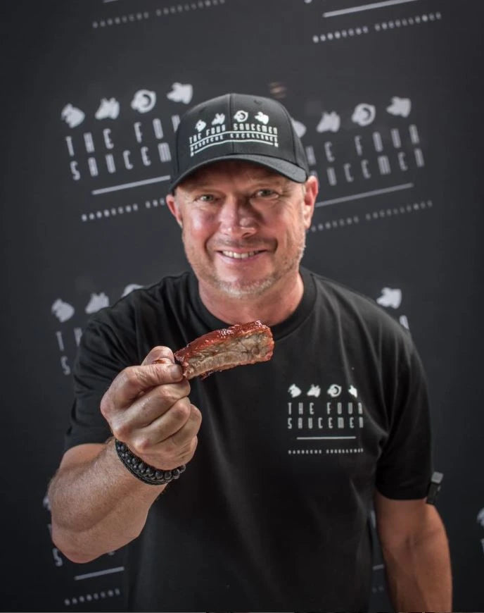 Pitmaster holding grilled meat seasoned with Manuka Hot Honey Rub at a BBQ competition