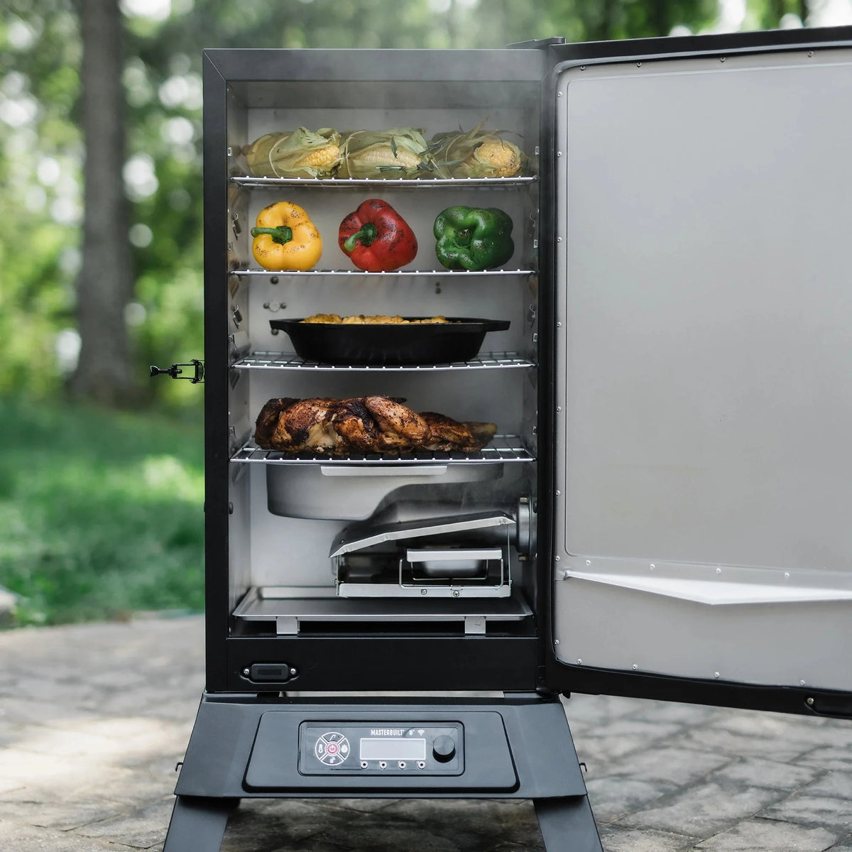 Masterbuilt 710 electric smoker with door open showing four chrome racks and water bowl