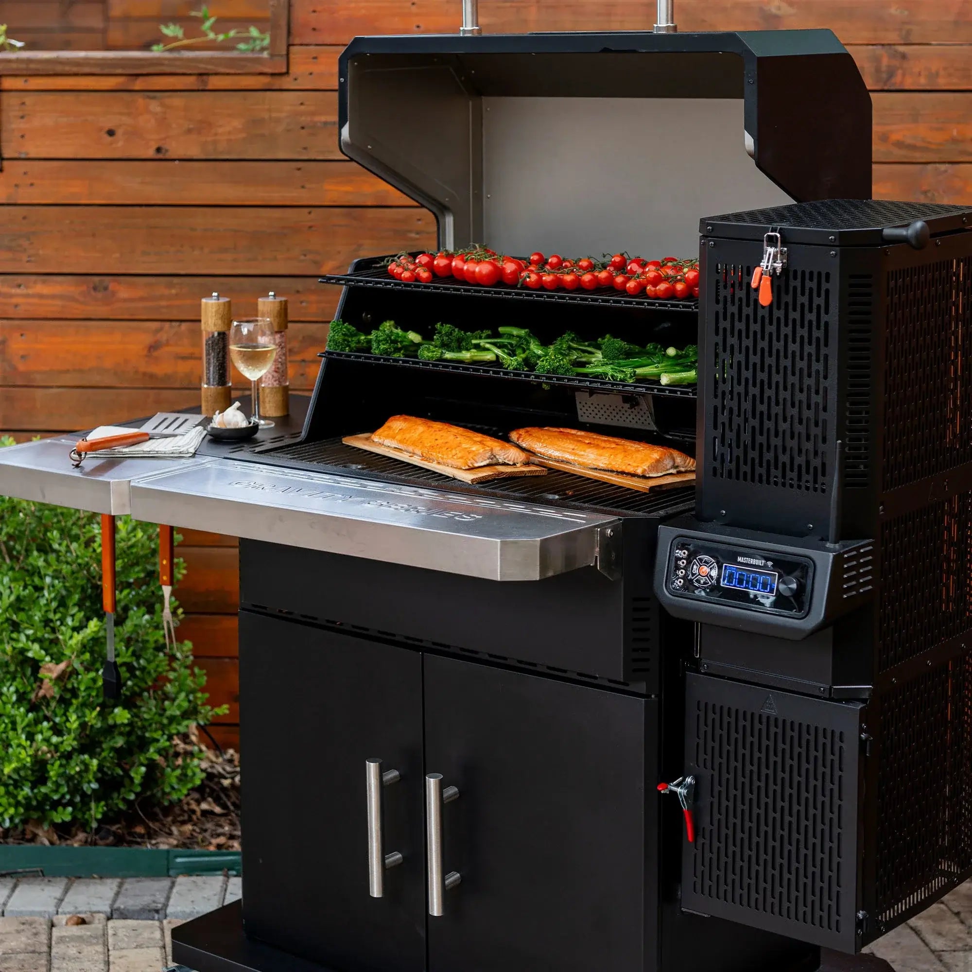 Masterbuilt Gravity Series 1150 digital charcoal BBQ cooking vegetables and meat outdoors