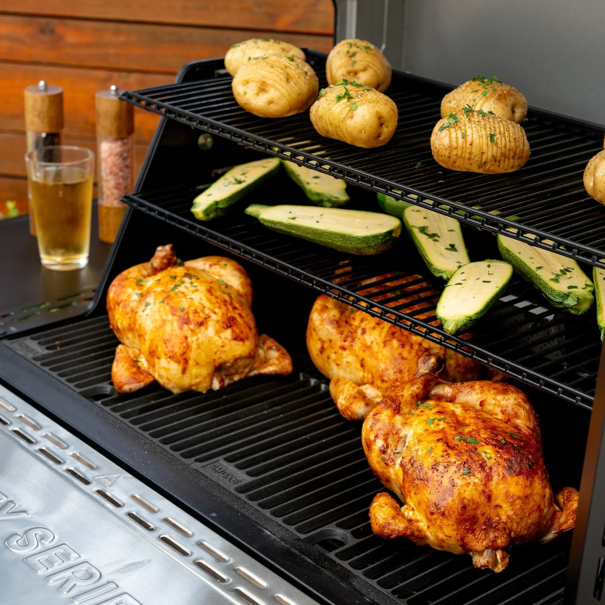 Whole chickens smoking inside the Masterbuilt Gravity Series 1150 charcoal BBQ smoker