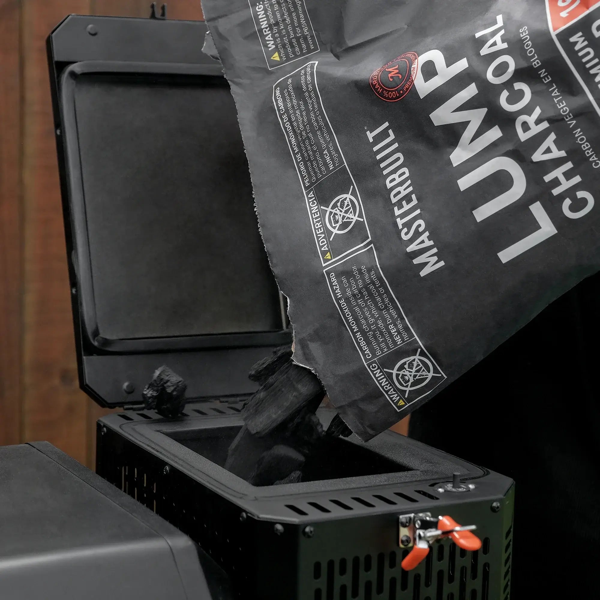 Filling the GravityFed charcoal hopper on the Masterbuilt Gravity Series 560 BBQ with Premium Hardwood Lump Charcoal for long lasting cooking.