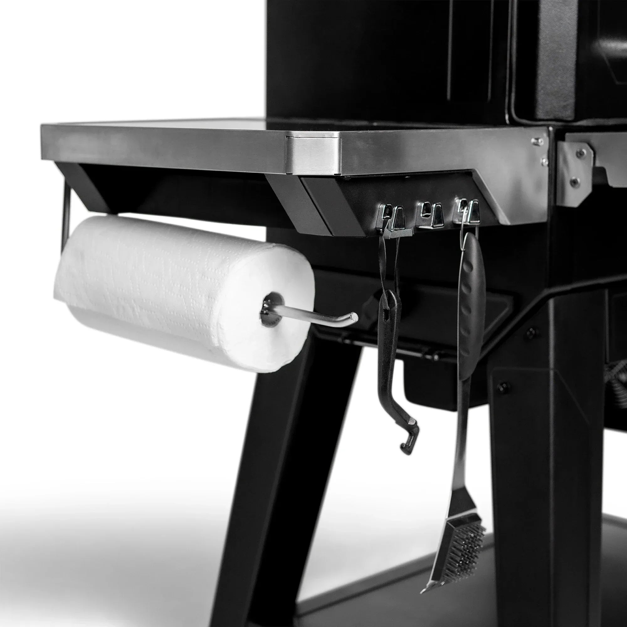 Masterbuilt Gravity Series XT Digital Charcoal BBQ featuring stainless steel side shelf with paper towel holder and integrated utensil hooks.