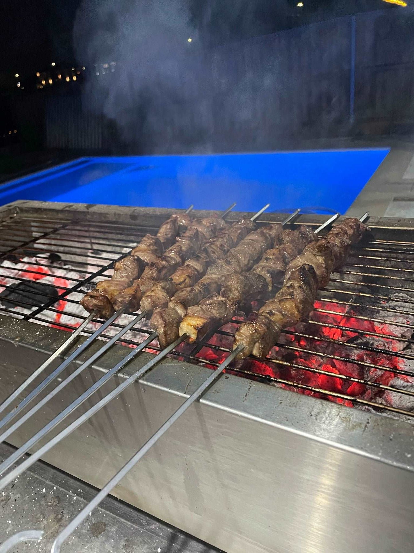 portable charcoal bbq on bench with shish kebabs