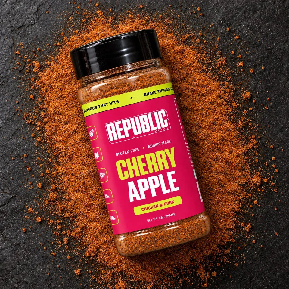 Republic Cherry Apple Chicken and Pork Seasoning jar on a dark surface surrounded by seasoning
