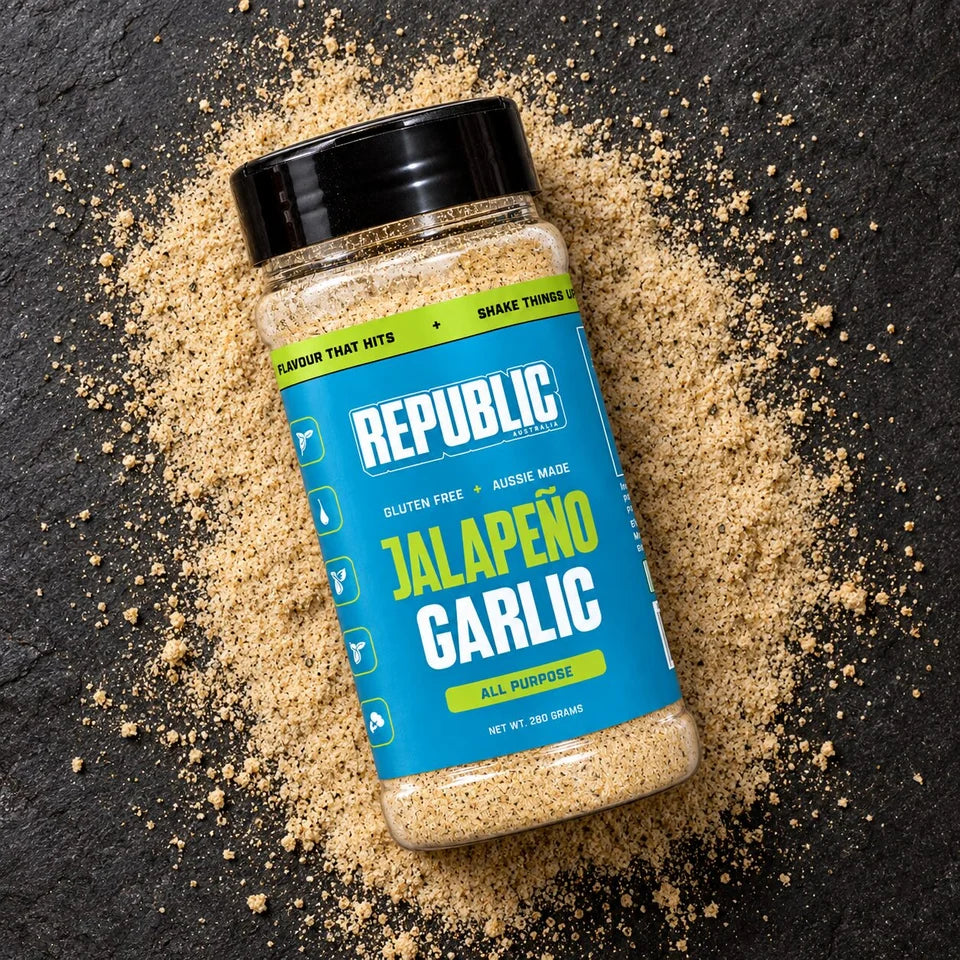 Republic Jalapeño Garlic Seasoning jar on a dark surface surrounded by seasoning
