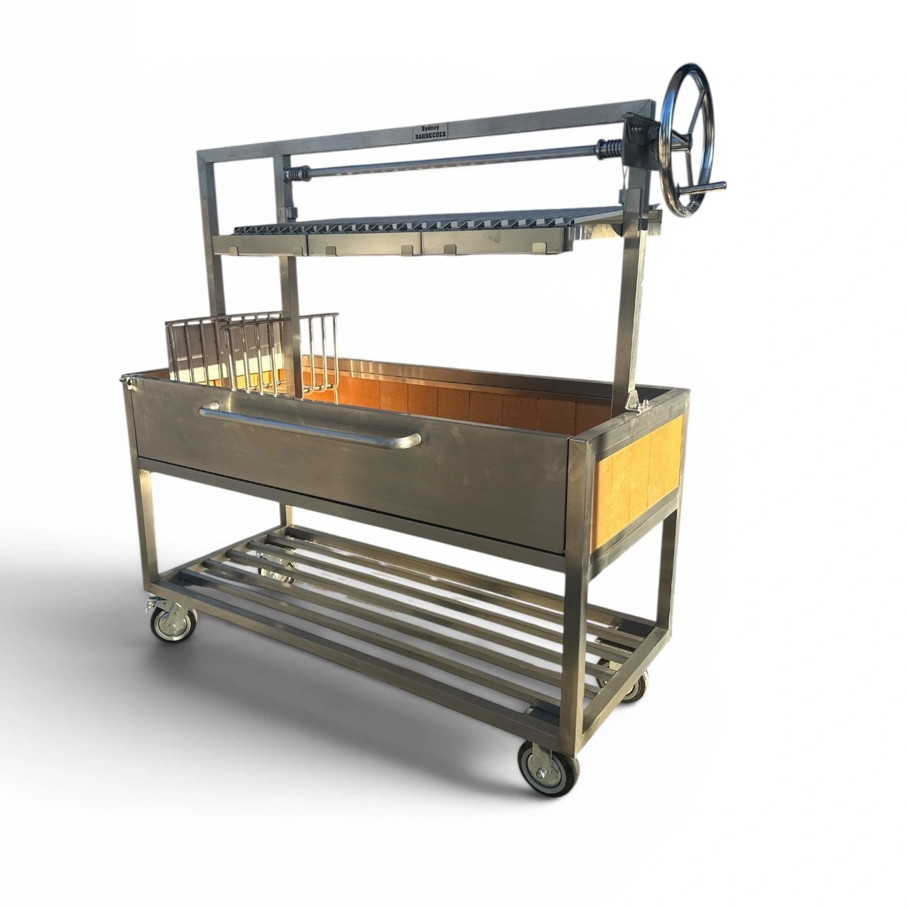 Angled view of the Sydney Barbecues Parrilla 1200 featuring 304 stainless steel construction, adjustable V channel grill and heavy duty castors.