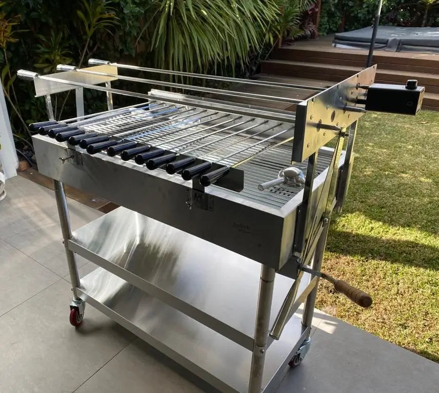 XL rotisserie charcoal grill set up outdoors in front of a timber deck